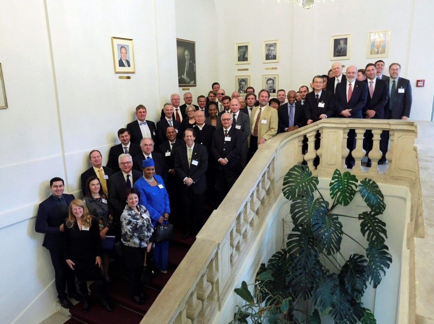 A group of people standing on the stairs in front of a wall.